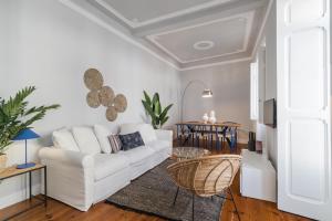 a living room with a white couch and a table at Casa Boma Lisboa - Elegant and Charming Apartment - Alcantara V in Lisbon