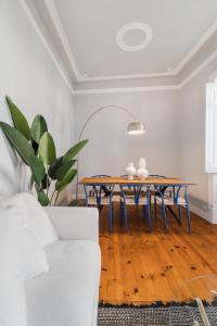 a living room with a table and a white couch at Casa Boma Lisboa - Elegant and Charming Apartment - Alcantara V in Lisbon
