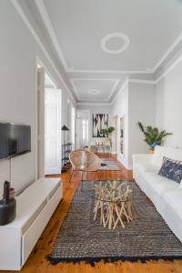 uma sala de estar com um sofá branco e uma mesa em Casa Boma Lisboa - Elegant and Charming Apartment - Alcantara V em Lisboa