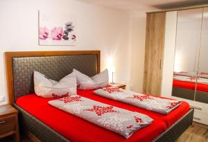 a bedroom with two beds with red and white pillows at Berghaus Egg in Jerzens