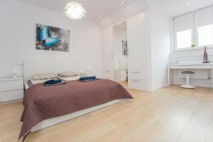 a white bedroom with a bed and a fireplace at Urban Jungle Apartment in the city center in Białystok