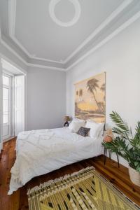 um quarto com uma cama com um quadro na parede em Casa Boma Lisboa - Elegant and Charming Apartment - Alcantara V em Lisboa