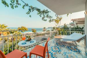 einen Balkon mit einem Tisch und Stühlen sowie Meerblick in der Unterkunft Hotel Rivage Taormina in Taormina