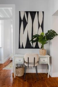uma secretária branca com uma cadeira e uma planta em Casa Boma Lisboa - Elegant and Charming Apartment - Alcantara V em Lisboa
