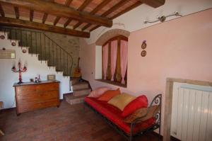 a living room with a red couch and stairs at La Capanna di Panpepato in Rosia