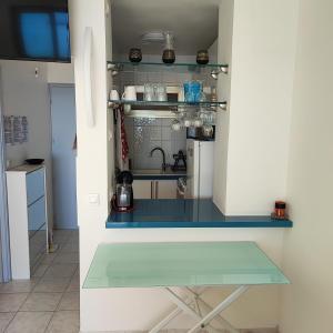 - une cuisine avec un comptoir en verre dans une pièce dans l'établissement Grand studio bord de mer- accès direct aux plages, à Saint-Laurent-du-Var