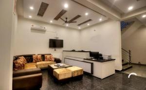 sala de estar con sofá y TV en Hotel Ark Avalon- Delhi International Airport en Nueva Delhi