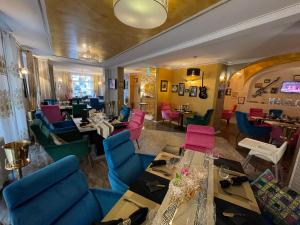 - un restaurant avec des tables et des chaises colorées dans une chambre dans l'établissement Boutiquehotel Mason, à Altenburg