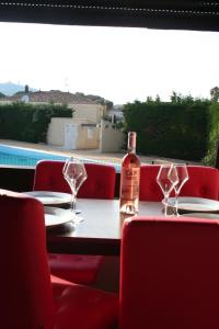 - une bouteille de vin assise sur une table avec des verres dans l'établissement Le Vénusia du CAP - Clim, stationnement, ménage et linge fournis, au Cap d'Agde