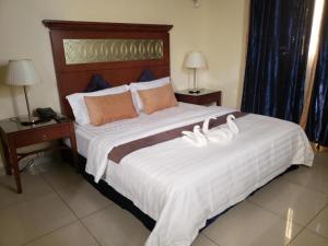 ジブチにあるRas Dika Hotelのベッドルーム1室(白い大型ベッド1台、テーブル2台付)