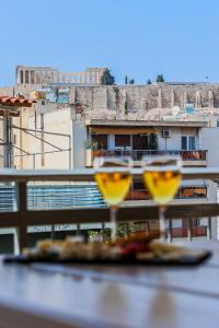two wine glasses sitting on top of a table at Penthouse Gem with Outstanding Acropolis View in Athens