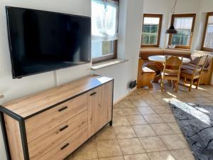 a living room with a large flat screen tv on a wall at Kleines Häuschen mit Bergblick in Eschenlohe
