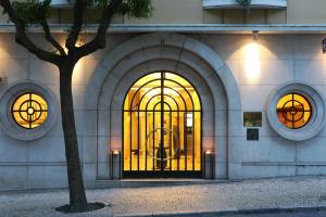 a building with a door with a tree in front of it at Hotel Britania Art Deco - Lisbon Heritage Collection - Avenida in Lisbon