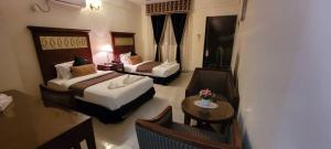 a hotel room with two beds and a table at Ras Dika Hotel in Djibouti