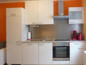 a kitchen with white cabinets and a sink at Ferienwohnung Am Lindenbaum in Kirnitzschtal