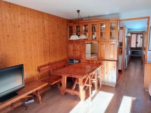 Il comprend une cuisine avec une table en bois et une télévision. dans l'établissement Apartamento con maravillosas vistas al lado de la estación, à Panticosa