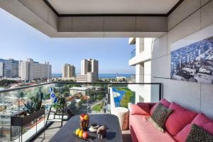 a living room with a couch and a view of the city at Amazing 2BR Condo with Sea View by HolyGuest in Tel Aviv