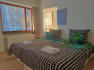 a bedroom with a bed with a black and white comforter at Säynätsalo Town Hall in Säynätsalo