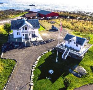 an aerial view of a white house with a flag at Lofoten Villa in Reine