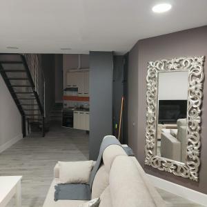 uma sala de estar com um sofá e um espelho em TEMPLE LOFT em Talavera de la Reina