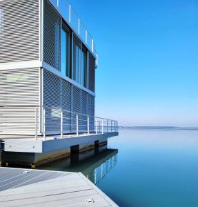 a building on the water next to a body of water at schwimmendes Ferienhaus Silent in Elsterheide