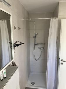 a bathroom with a shower with a shower curtain at Ferienwohnung Zum Eifelelch in Daun +9 photos