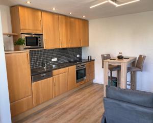 a kitchen with wooden cabinets and a small table with a table at Ferienwohnung Zum Eifelelch in Daun