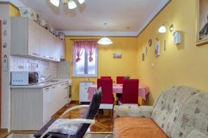 cocina y sala de estar con mesa y sillas rojas en Apartment Simeone, en Zadar