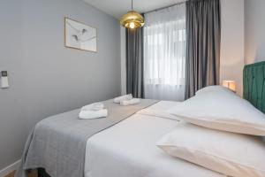 1 dormitorio con 1 cama con sábanas blancas y ventana en Exclusive Apartman AnaMarino, en Zadar