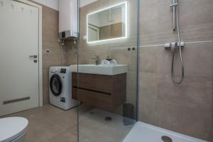y baño con lavabo y lavadora. en Exclusive Apartman AnaMarino, en Zadar
