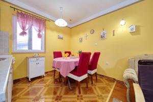 a dining room with a table and red chairs at Apartment Simeone in Zadar