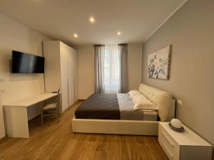 ein kleines Schlafzimmer mit einem Bett und einem Schreibtisch in der Unterkunft LEVANTE Central Rooms in Levanto