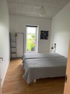 um quarto com uma cama grande e uma janela em Refshalegaard em Engesvang