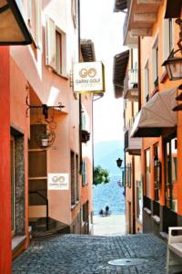 una calle de la ciudad con edificios y el océano en el fondo en Depandance Garni Golf en Ascona