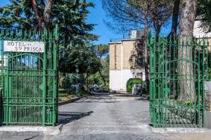 une porte verte dans une rue avec un bâtiment dans l'établissement Hotel Santa Prisca, à Rome