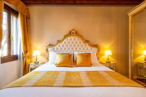 a bedroom with a large white bed with orange pillows at Laguna D'oro Luxury Apartments in Venice