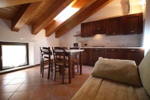 una cucina con tavolo, sedie e un divano di Residence Aquila - Mono Corno Bussola a Brusson Altre 9 foto