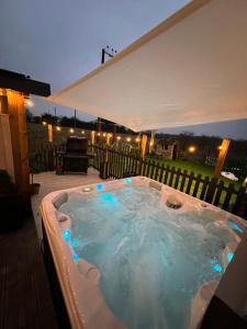 a jacuzzi tub on a patio at night at Stunning 5 Bedroom Victorian home with optional hot tub in Pershore +23 photos