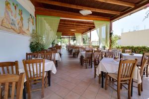 Marirena Hotel في أمودارا هيراكليو: غرفة طعام مع طاولات وكراسي في مطعم