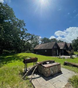 a stone fire pit in front of a house at The Mill House on the Brooks South Downs West Sussex Sleeps 15 in Hardham