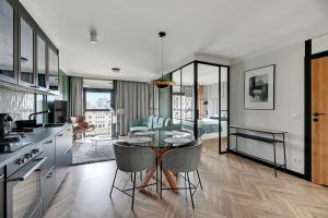 Il comprend une cuisine et un salon avec une table et des chaises. dans l'établissement Comfort Apartments Rezydencja Wintera, à Gdańsk