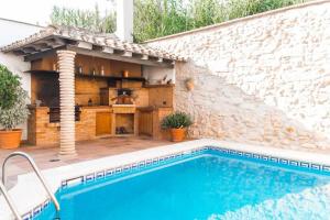 una casa con piscina junto a una pared de piedra en Family Home Jaume II Casa Familiar Jaume II, en Llucmajor