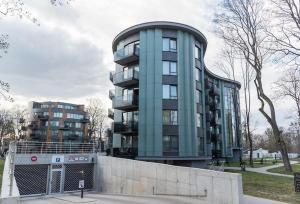 een hoog blauw gebouw met een hek ervoor bij Valensia Apartment in Druskininkai