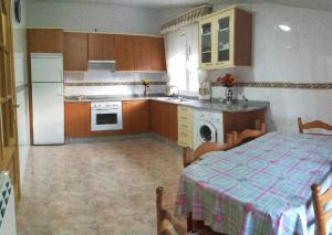 a kitchen with a table and a refrigerator and a stove at Casa Rural Elias in Molinaseca