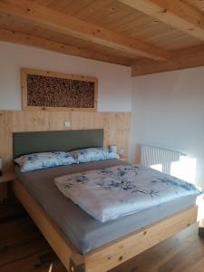 een groot bed in een slaapkamer met een houten plafond bij Winzerei Schober in Grubberg