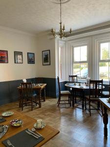 a dining room with tables and chairs and windows at The Cedars Ashby in Ashby de la Zouch
