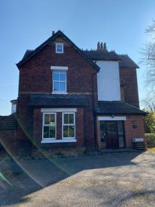 uma casa de tijolos com janelas brancas do lado em The Cedars Ashby em Ashby de la Zouch