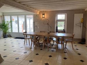 a dining room with a wooden table and chairs at Le Clos des Châteaux in Chitenay