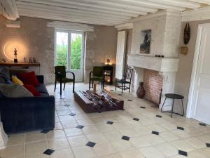 a living room with a couch and a fireplace at Le Clos des Châteaux in Chitenay