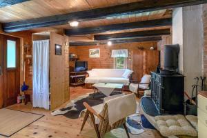 a living room with a room with a bed and a stove at Cabin In The Woods Vukelic in Stubicke Toplice